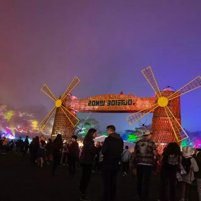 一群参加音乐节的人在夜晚的霓虹灯下参加了贝博体彩app的“外域”音乐节.